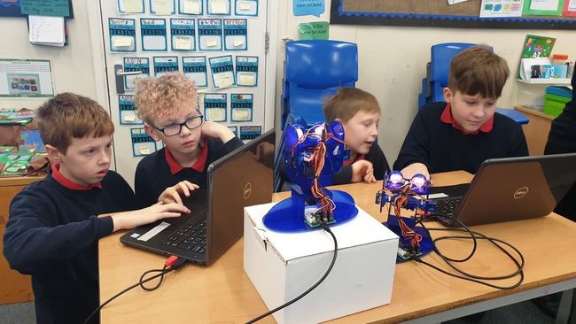 Four boys on devices working at a CyberFirst schools event