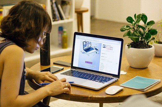 Person sat at a table with their laptop open working from home