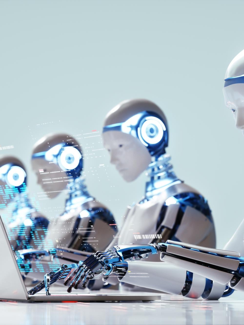 Humanoid robots working at laptops