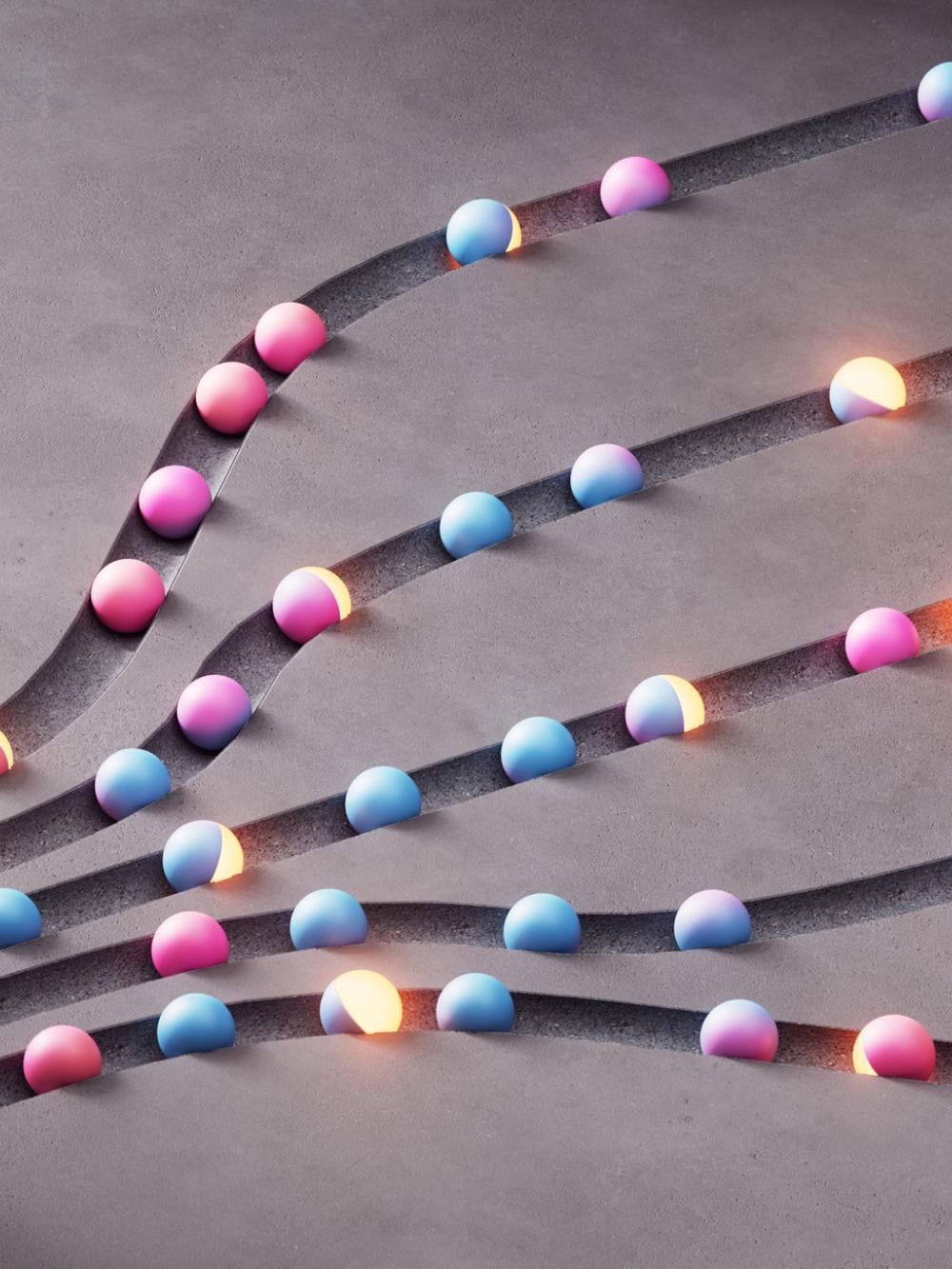 Abstract branching grooves on a concrete surface filled with glowing spheres, illustrating routing, load balancing, parallel processing and flow optimization.