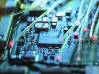 a close up of a computer circuit board with a central microchip surrounded by electrical components