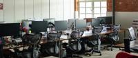 Industrial style office interior with pipework, exposed brick walls and ergonomic furniture