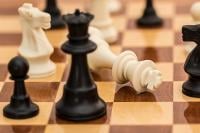 close up of a chessboard and the white king has been knocked over accepting defeat
